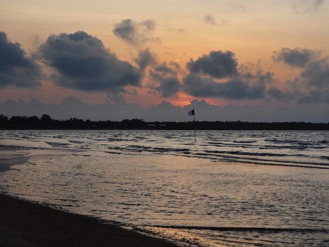 Dawn breaks over Blue Mud Bay, where a sea rights flag can be seen waving at the intertidal mark Picture: Matt Garrick