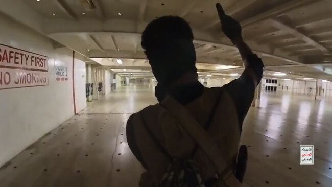 A Houthi rebel shouts anti-American and anti-Israel slogans as he crosses a deck of the Galaxy Leader.