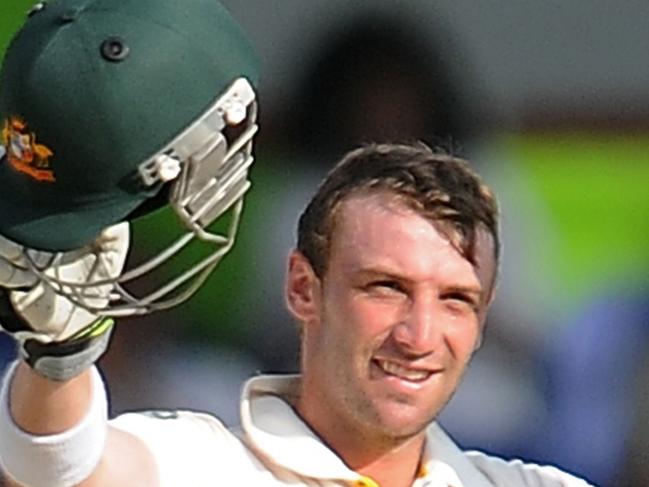 Australian batsman Phillip Hughes raises his bat and helmet in celebration after scoring a century (100 runs) during the fourth day of the third and final Test match between Australia and Sri Lanka at The Sinhalese Sports Club (SSC) Ground in Colombo on September 19, 2011. Phil Hughes hit timely form as Australia fought hard to wriggle out of a tight corner in the third and final Test against Sri Lanka. AFP PHOTO/ Lakruwan WANNIARACHCHI