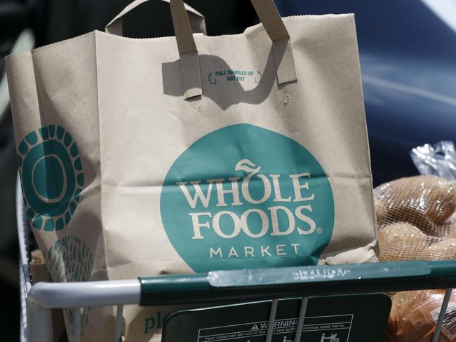 A Whole Foods Market purchase awaits placement in a car trunk, outside the Jackson, Miss., store Friday, June 16, 2017.   Amazon is buying Whole Foods in a stunning move that gives it hundreds of stores across the U.S.,  a brand-new laboratory for radical retail experiments that could revolutionize the way people buy groceries. (AP Photo/Rogelio V. Solis)