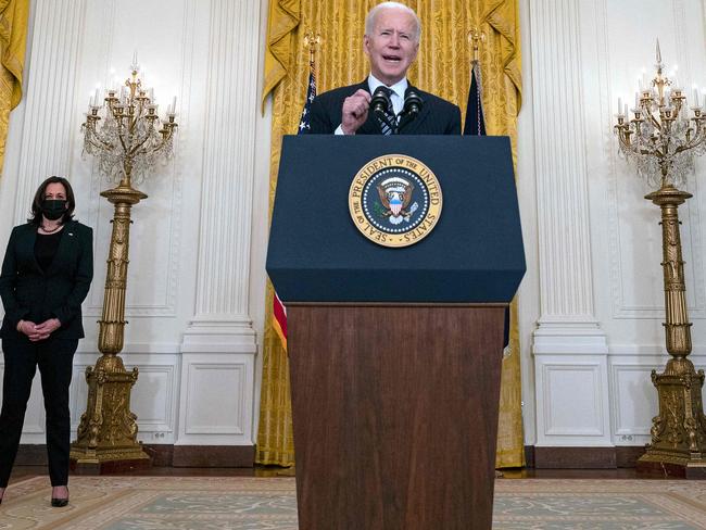 US President Joe Biden, flanked by US Vice Presidente Kamala Harris (L), speaks on the national vaccination efforts in the East Room of the White House in Washington, DC on March 18, 2021. (Photo by Jim WATSON / AFP)