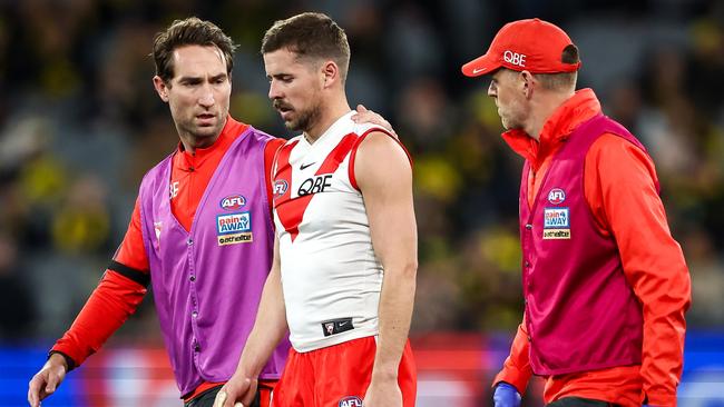 Jake Lloyd is walked off the MCG by medical staff. Picture: Dylan Burns/AFL Photos via Getty Images