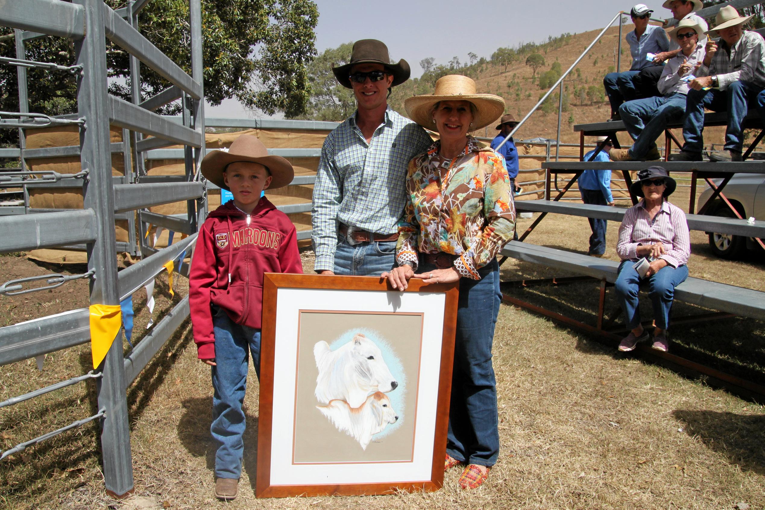 Presenting the "Lucky Bid Card" prize to Master Holt of Cedar Brook Brahmans are Ewan and Felicity Rockemer.