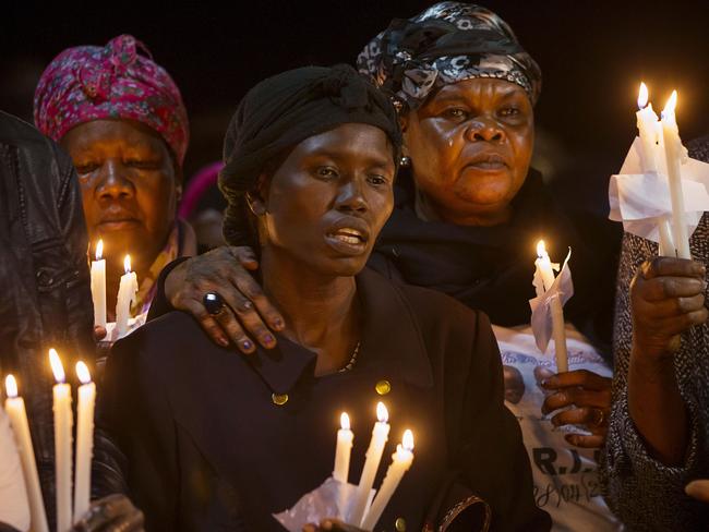 Akon Guode is comforted by family and friends at a memorial event. Picture: Ian Currie