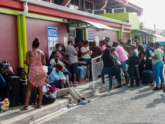 People queue outside a bus station in Scarborough, Trinidad and Tobago, before the arrival of Hurricane Beryl. (Photo by Clement George Williams / AFP)