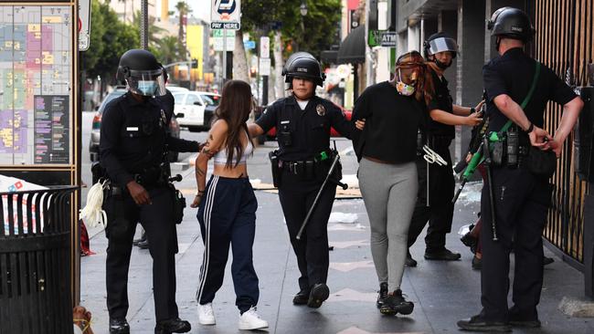 Police officers arrest people after a store was looted in Hollywood, California after a third day of protests and looting. Picture: AFP