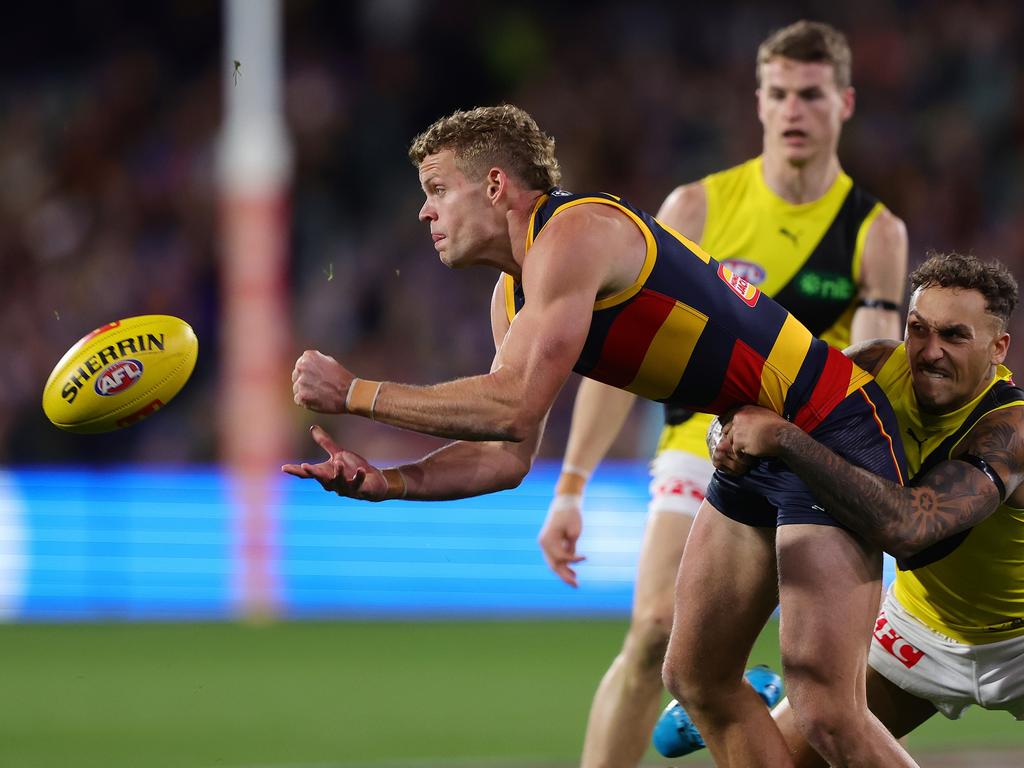 Mitchell Hinge gets the handball off at the Adelaide Oval. Picture: Sarah Reed/AFL Photos via Getty Images.