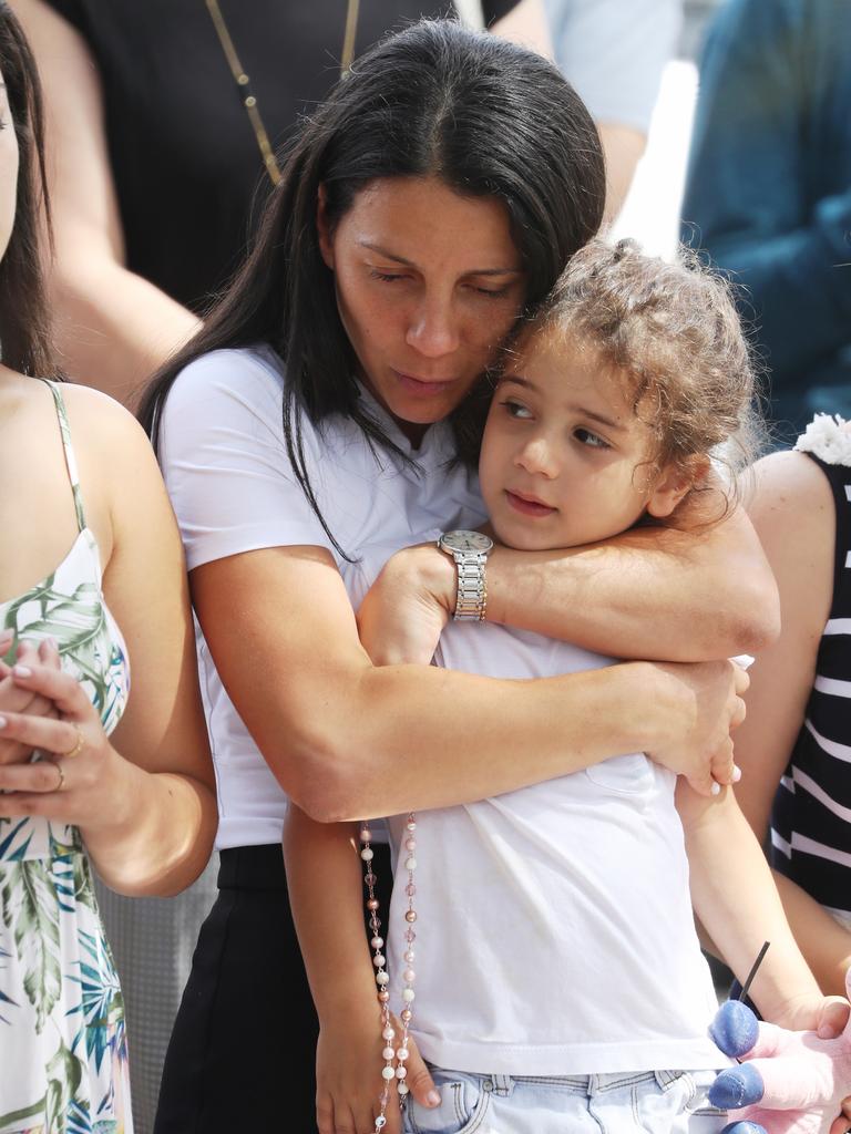 Leila clutching a child at the crash site. Picture: John Grainger