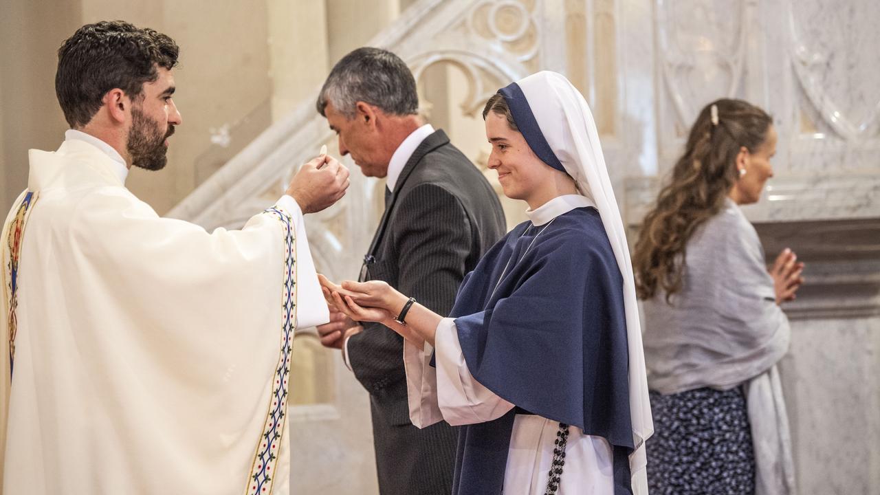 Father Nathan Webb gives communion to Sister Rose Patrick OConnor (his sister Nancy Webb). Ordination of Nathan Webb at St Pat's Cathedral. Saturday, June 25, 2022. Picture: Nev Madsen.