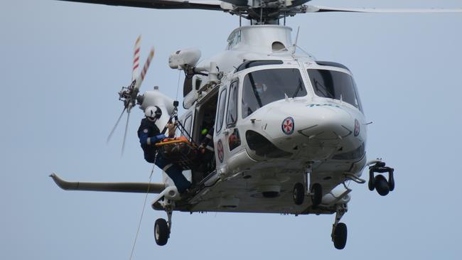 A doctor, in his 60s, was winched from rocks at Forresters Beach by the Toll rescue helicopter after crashing his paraglider. Picture: Richard Noone