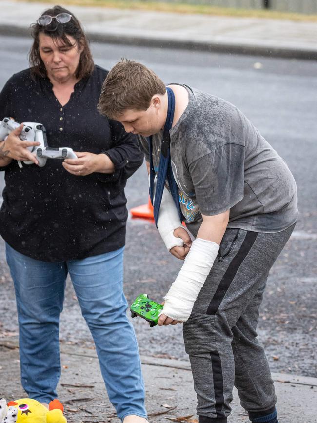 Beau, with both arms in plaster casts, lays three gaming controllers and a teddy. Picture: Jason Edwards