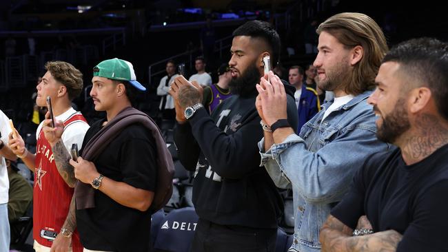 Reece Walsh, Kotoni Staggs, Payne Haas, Patrick Carrigan, and Adam Reynolds look on courtside prior to a game between the Los Angeles Lakers and the San Antonio Spurs.