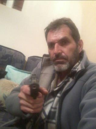 Roman Heinze poses with a gun in a photo from social media.