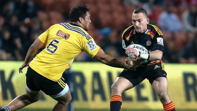 HAMILTON, NEW ZEALAND - JULY 04: Aaron Cruden of the Chiefs skips inside Jack Lam of the Hurricanes during the round 18 Super Rugby match between the Chiefs and the Hurricanes at Waikato Stadium on July 4, 2014 in Hamilton, New Zealand. (Photo by Jason Oxenham/Getty Images)