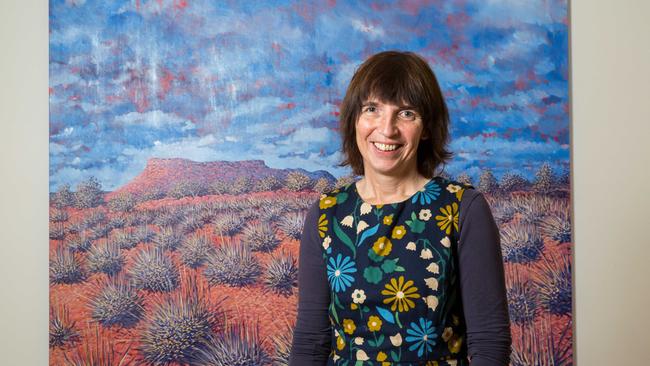 Alice Springs artist Sarah Brown in front of her painting of the Kintore men's mountain. Sarah's exhibition 'Here' opens tonight at the Araluen Arts Centre, with all painting sales being donated to Purple House. June 28 2017. Photo: EMMA MURRAY