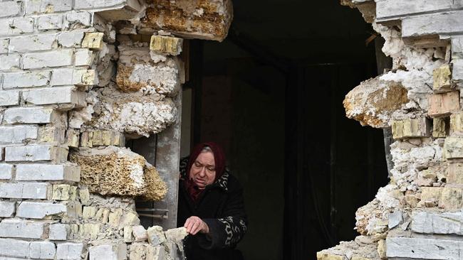 Local resident Nadiya, 65, shows a hole in a house after shelling in the village of Zalissya, northeast of Kyiv, on April 12.