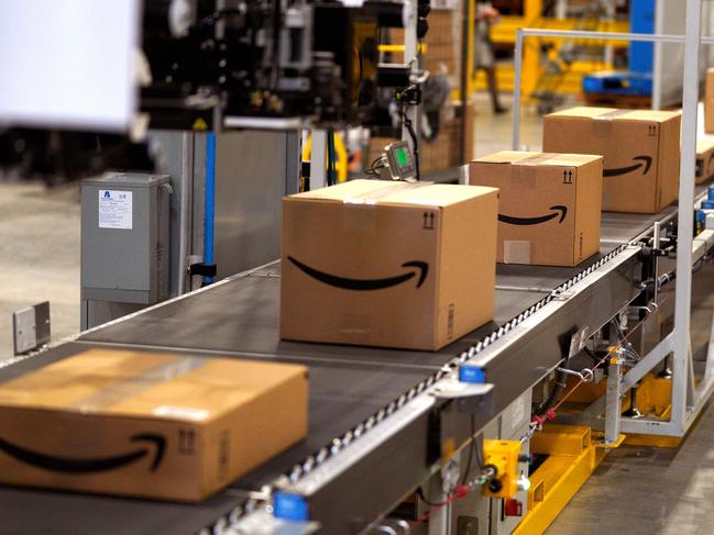 (FILES) In this file photo taken on May 02, 2018, packed orders move down a converyor belt at the Amazon fullfillment center in Aurora, Colorado. - Amazon said Monday, May 13, 2019 it was offering employees $10,000 to quit their jobs and become independent package delivery entrepreneurs for the online retail colossus. An Amazon statement said the latest incentive would also include three months of wages for employees who want to start their own delivery enterprise, and that they would be assured 