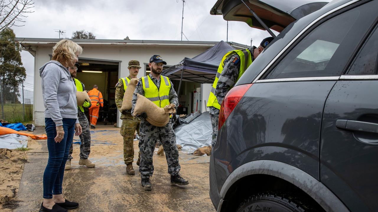 Royal Australian Navy and Australian Army personnel from Joint Task Force 629 load sandbags into a local lady’s vehicle at the Mount Druitt State Emergency Service depot.