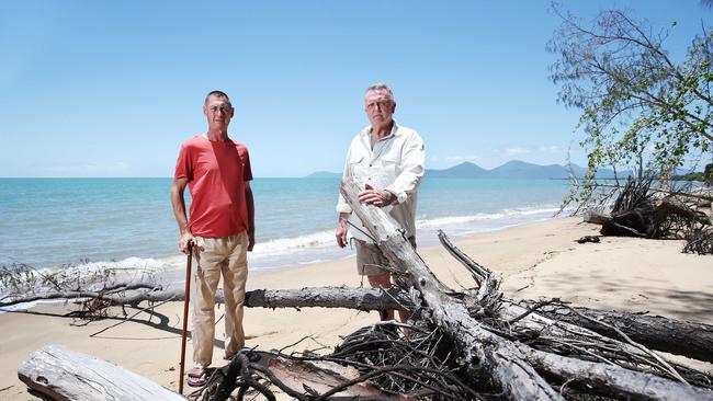 Holloways Beach is suffering from severe erosion since Cairns Regional Council installed rock wall groynes near the swimming area. Holloways Beach resident Gary Handler looks at mature trees that have fallen down on the foreshore with former councillor Brian Down. PICTURE: BRENDAN RADKE