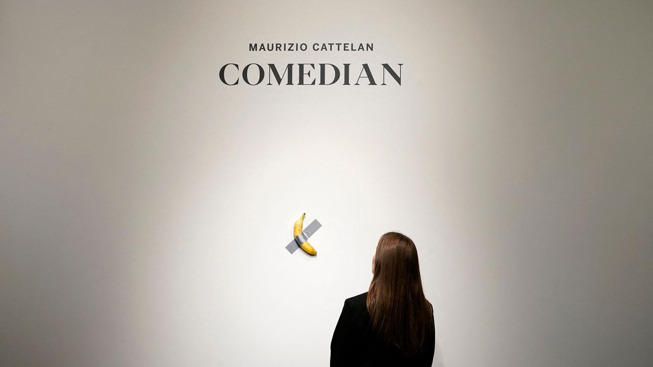 Is this art or a joke or both? A woman looks at Italian visual artist Maurizio Cattelan’s duct-taped banana entitled "Comedian," at Sotheby's in New York, on October 25, 2024. The 2019 debut of the edible creation at the Art Basel show in Miami Beach sparked controversy and raised questions about whether it should be considered art -Cattelan’s stated aim. Picture: Timothy A. Clary/AFP