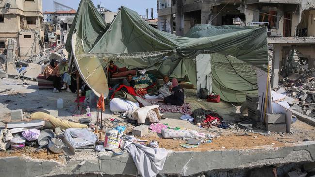 Palestinians shelter in a makeshift tent made from a parachute used to airdrop food aid, set up on the rubble of their home in a devastated area around Gaza's Al-Shifa hospital. Picture: AFP