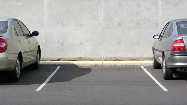 A vacant parking space just waiting for a reverse parker to grace between the white lines.