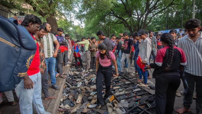 Fans of the Royal Challengers Bengaluru (RCB) look for footwear in a pile of discarded shoes and slippers after crowds got out of control on Wednesday. (Photo by Abhishek Chinnappa/Getty Images)