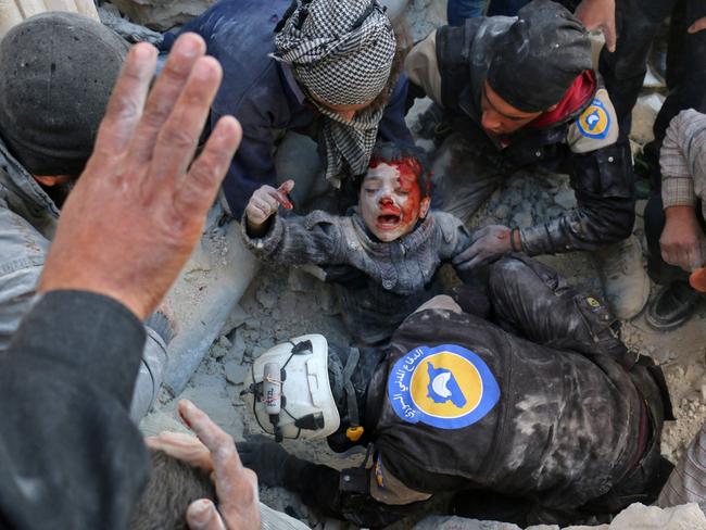 Syrian civil defence volunteers, known as the White Helmets, rescue a boy from the rubble following a reported barrel bomb attack on the Bab al-Nairab neighbourhood of the northern Syrian city of Aleppo on November 24, 2016. Picture: AFP PHOTO / AMEER ALHALBI