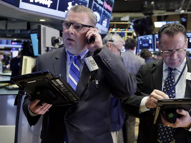 Traders Mathias Roberts, left, and Edward Curran work on the floor of the New York Stock Exchange, Tuesday, Nov. 10, 2015. Stocks are inching lower in early trading Tuesday, extending a slump that has brought the market lower for the past four trading days. (AP Photo/Richard Drew)