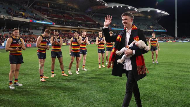 Paul Seedsman of the Crows walks off the oval with his baby after retiring during to concussion. Picture: Getty Images