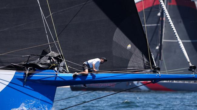 A crewmen aboard LawConnect on the bow sprit for a sail change during a lead-up race.