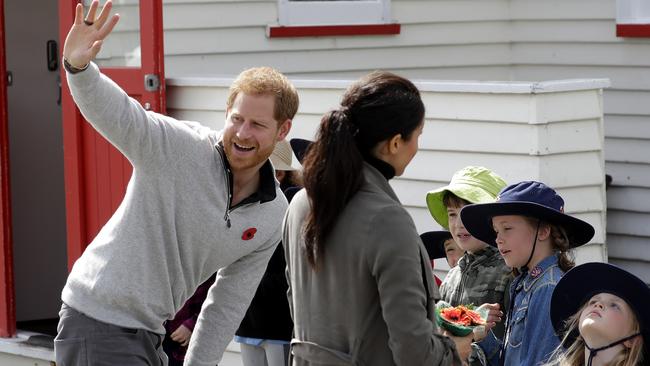 Prince Harry and Meghan react after meeting children in New Zealand. Picture: AP