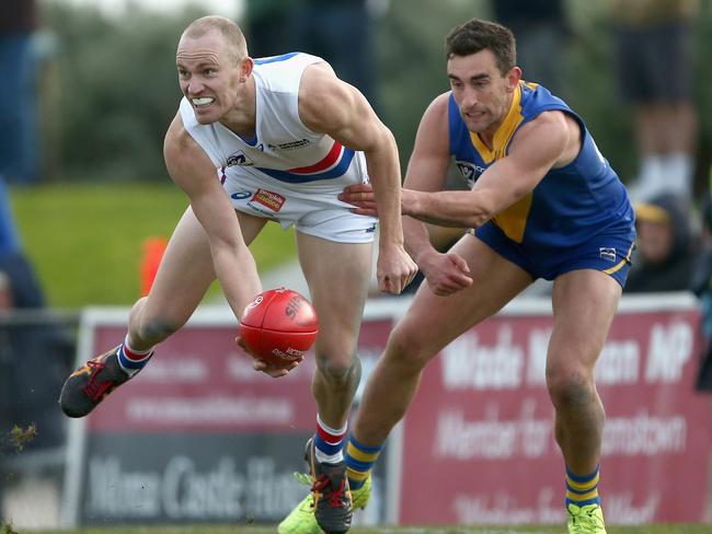 Anthony Bruhn (left) of Footscray handballs during a VFL match.