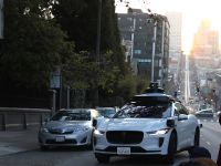 SAN FRANCISCO, CALIFORNIA - APRIL 09: A Waymo self-driving car stops while driving as people stand in the middle of the street to photograph the sunrise on April 09, 2024 in San Francisco, California. Dozens of people came out to see and photograph the biannual phenomenon dubbed "California Henge" when the sun falls perfectly between city blocks.   Justin Sullivan/Getty Images/AFP (Photo by JUSTIN SULLIVAN / GETTY IMAGES NORTH AMERICA / Getty Images via AFP)