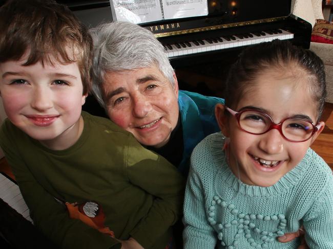 Daphne Proietto has been nominated for an Inspiration Medal for giving children with disabilities free piano lessons. Children who take her classes, which she takes at her home after her full-time job as a music teacher, show remarkable progress. Daphne with Marco Orkibi, 8, on the left, who has Autism, and Aban Bazldjou, 7, on the right who has Cerebral Palsy. Picture: Alex Coppel.