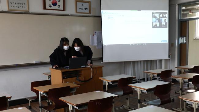 Teachers wear masks as they prepare a lesson on the first day of online class in an empty classroom. Picture: Chung Sung-Jun/Getty Images