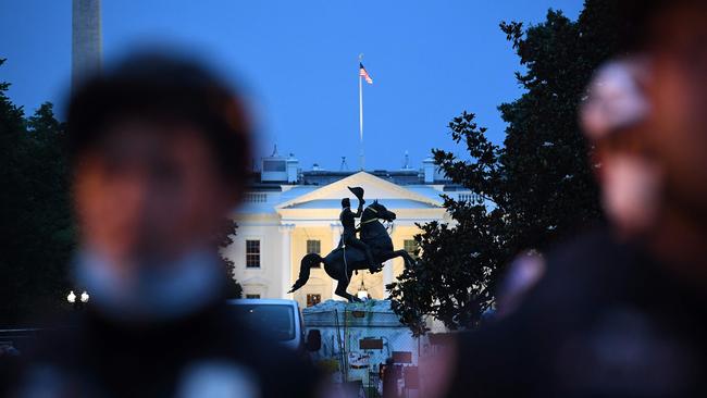 A row of police officers stand in a row with the equestrian statue of former US President General Andrew Jackson behind, after protesters tried to topple it, at Lafayette square, in front of the White House, in Washington. Picture: Eric Baradat/AFP