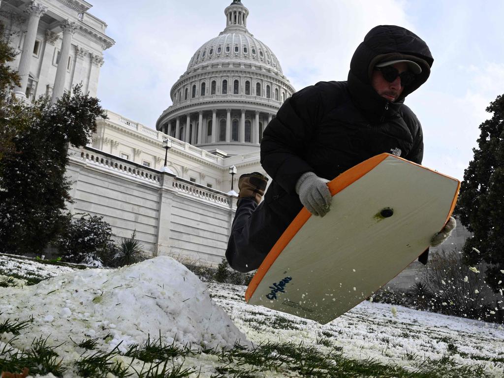 A man enjoys a sled ride near the US Capitol in Washington, DC after the area received 5-10cm of snowfall. Picture: Brendan Smialowski/AFP