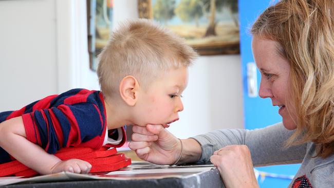 Ina Mills gives son Roki, 3, physical therapy at their Newport home. Picture: Troy Snook