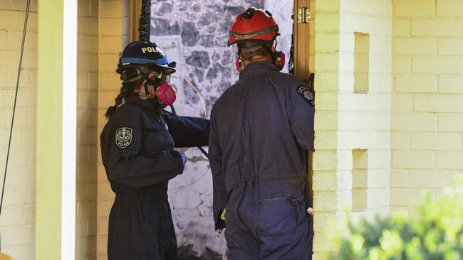 Fire investigators at the fire-destroyed cottage. Picture: Mark Brake