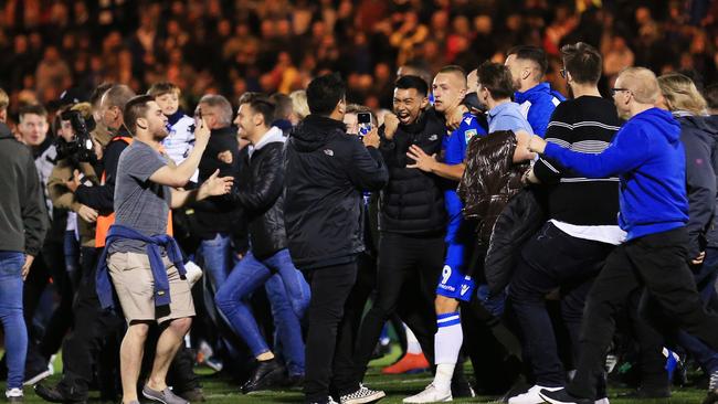 Colchester United’s Luke Norris is mobbed by fans after the League Two team defeated Tottenham Picture: Getty Images