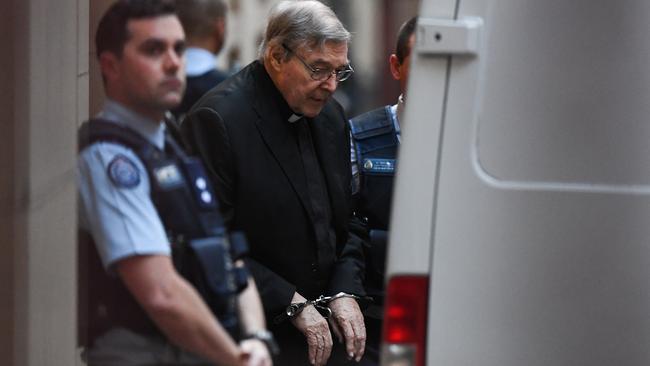 George Pell is led away by police after the day’s hearing in the Victorian Supreme Court yesterday. Picture: AAP