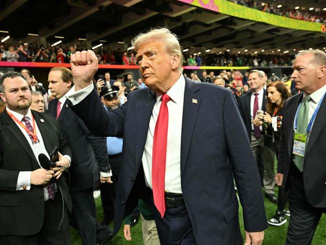 Mr Trump raises his fist as he is cheered on by Kansas City Chiefs and Philadelphia Eagles fans. Picture: AFP