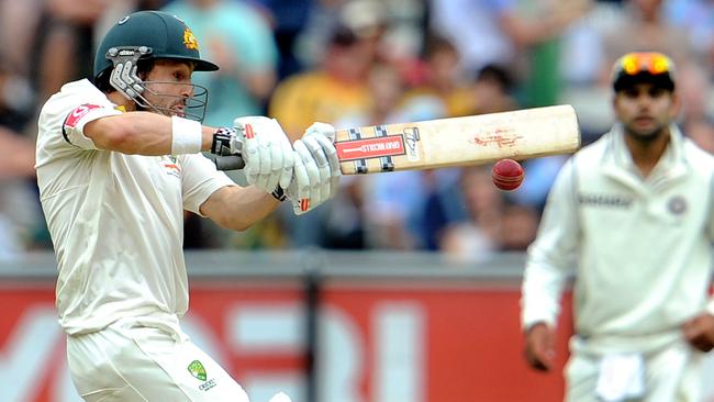 Australian batsman Ed Cowan pulls a ball away as Indian fieldsman Virat Kohli looks on.