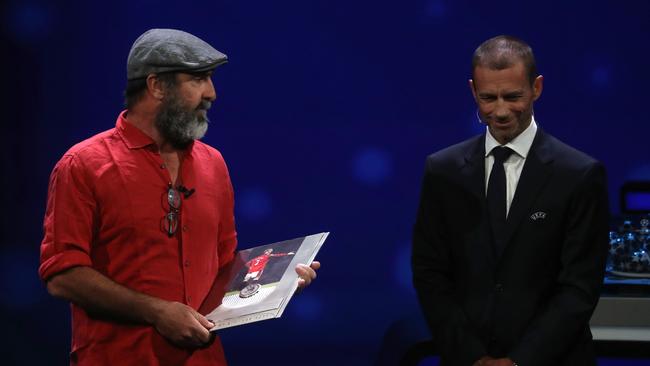 Former French international Eric Cantona, left, receives the UEFA President's Award during the UEFA Champions League football group stage draw ceremony in Monaco. Picture: Valery HACHE / AFP