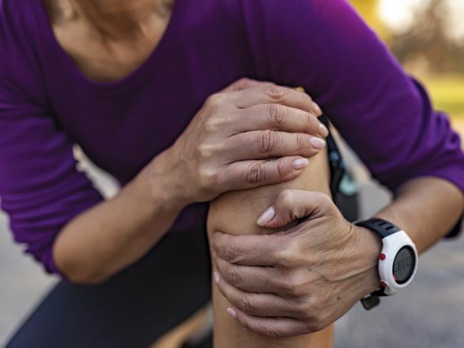 Cropped Image of Senior Woman Runner Hold Her Sports Injured Knee Outdoor. Injury From Workout Concept. Pain of Body Part and Bone Broken Theme