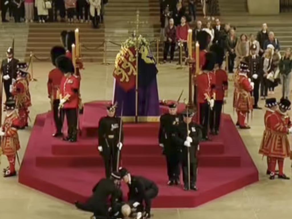 Two police officers quickly rushed to help a royal guard after he fainted. Picture: Supplied