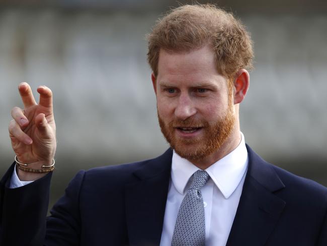 Prince Harry seems to be showing the rugby league kids a few secret signals they can use on the field. Picture: AFP