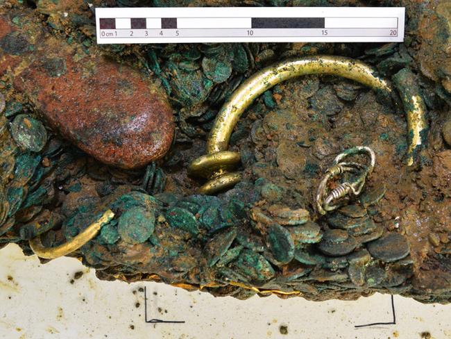 Exposed ... Part of a golden torc emerging from a solid mass of coins, jewellery and bullion found on the island of Jersey. Source: Jersey Heritage