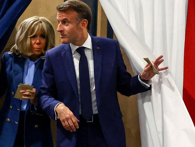 France's President Emmanuel Macron and his wife Brigitte Macron exit a polling booth during the final day of marathon EU elections. Picture: AFP